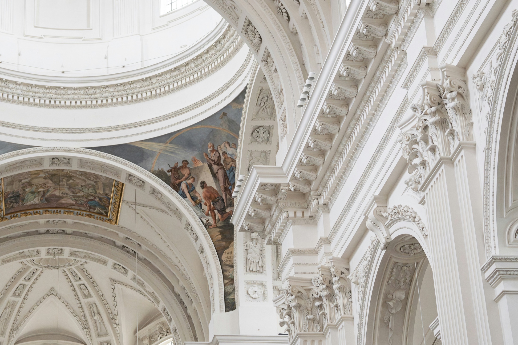 Ornate white architectural arches and painted frescoes